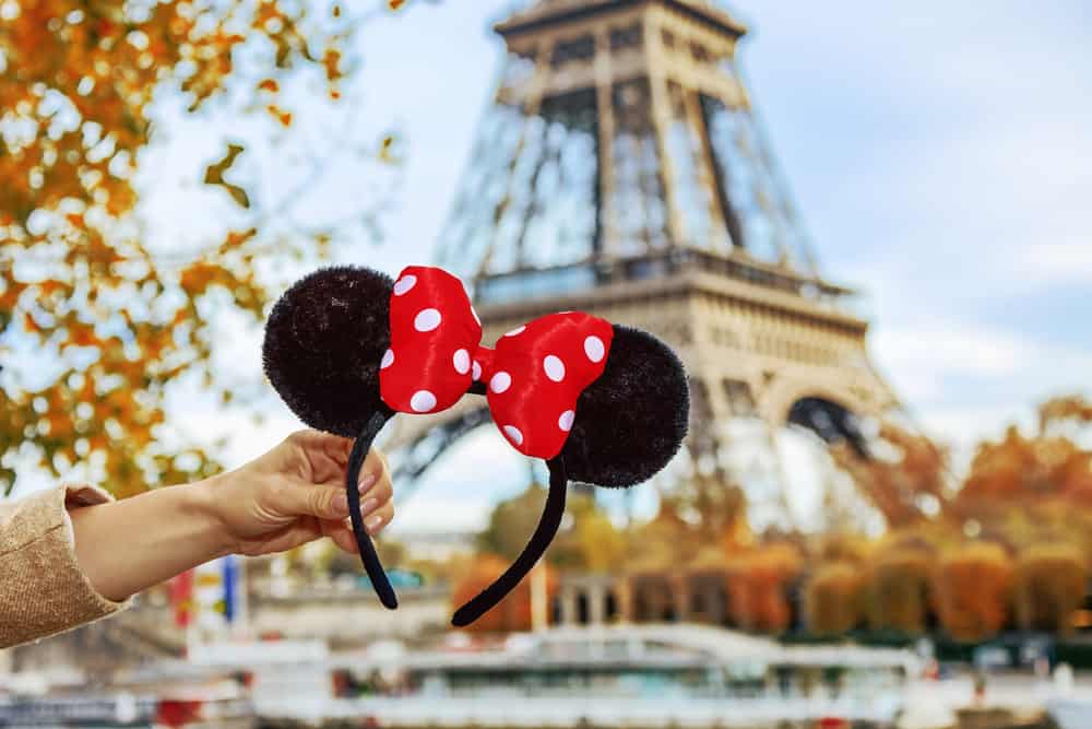 Closeup on Minnie Mouse Ears in female hand on embankment near Eiffel tower in Paris