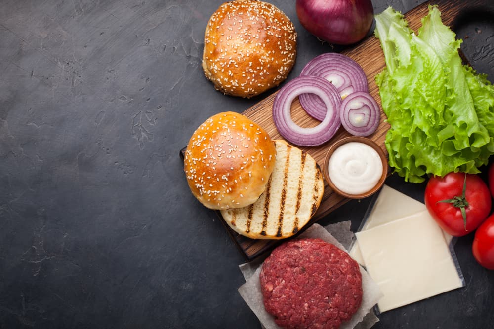 Fresh ingredients for Burger on dark stone table