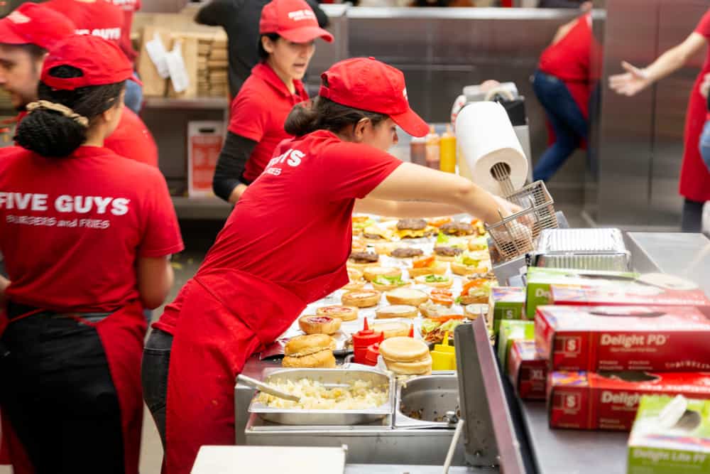 Young woman working in a Five Guys fast food chain