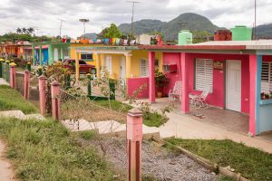 Musician Salsa carries a conga while walking the streets of Trinidad Cuba with a friend