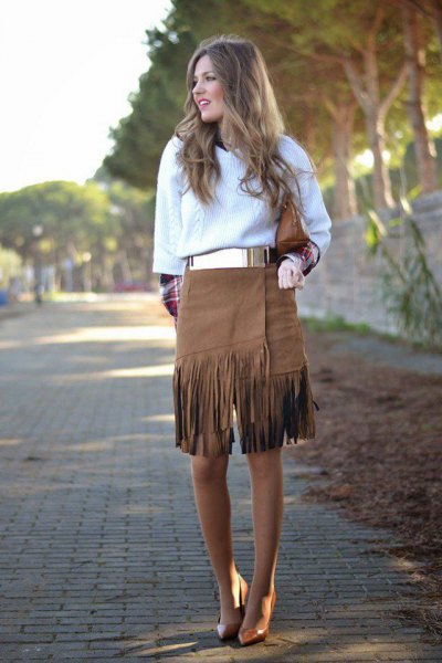 white cable knit sweater with metal belt and knee length fringe skirt