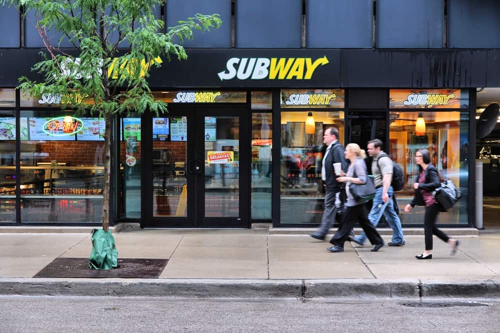 People walk past Subway sandwich store