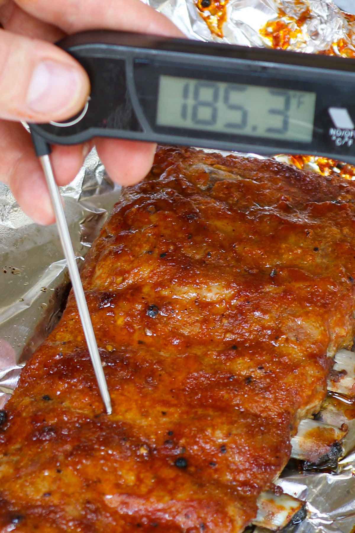Check the internal temperature of the ribs and get a reading of 185°F indicating they are ready