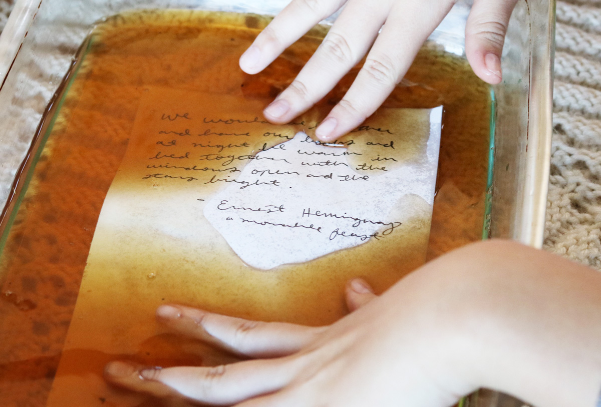 The tea leaves are sprinkled on a sheet of tea-dyed paper while it dries.