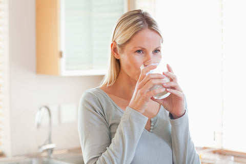 Woman drinking water to avoid neck wrinkles