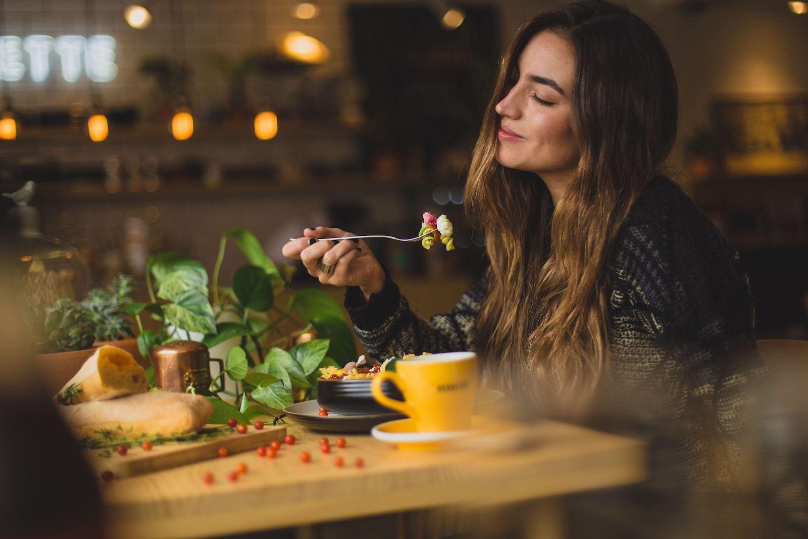 Rotten intestines: A smiling woman eats at a healthy restaurant