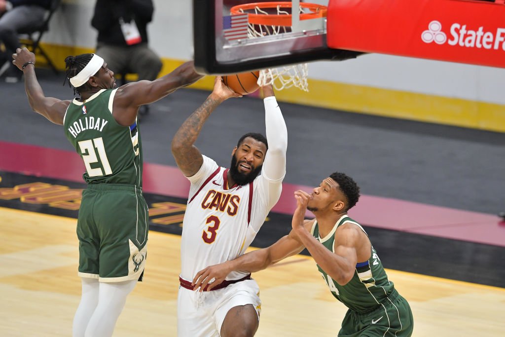 CLEVELAND, OHIO - FEBRUARY 6: Andre Drummond #3 of the Cleveland Cavaliers drives up the basket while under pressure from Jrue Holiday #21 and Giannis Antetokounmpo #34 of the Milwaukee Bucks during the 4th round at Rocket Mortgage Fieldhouse on Feb. 2021 in Cleveland, Ohio. NOTE TO USERS: User expressly acknowledges and agrees that, by downloading and/or using this photo, user agrees to the terms and conditions of the Getty Images License Agreement. (Photo by Jason Miller / Getty Images)