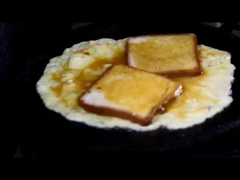 two slices of bread on a delicious cooking omelet