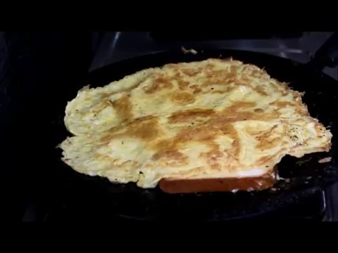 cook by flipping bread with omelette
