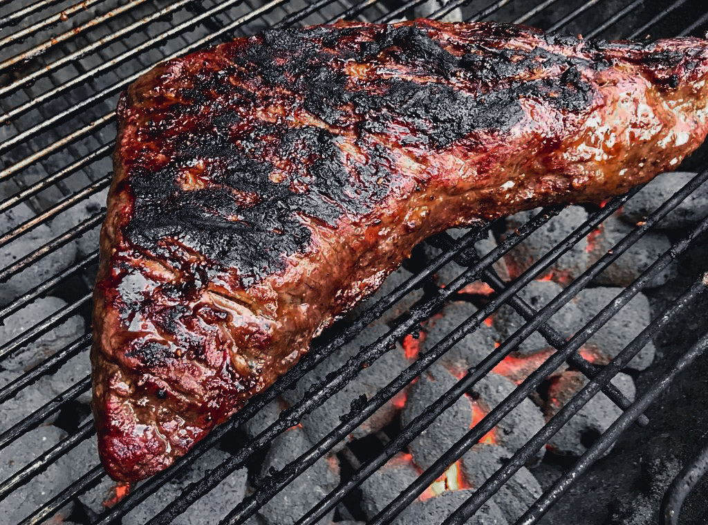 Photo of three-way steak on a charcoal grill