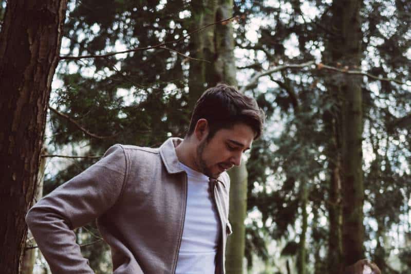 Man standing next to trees during the day