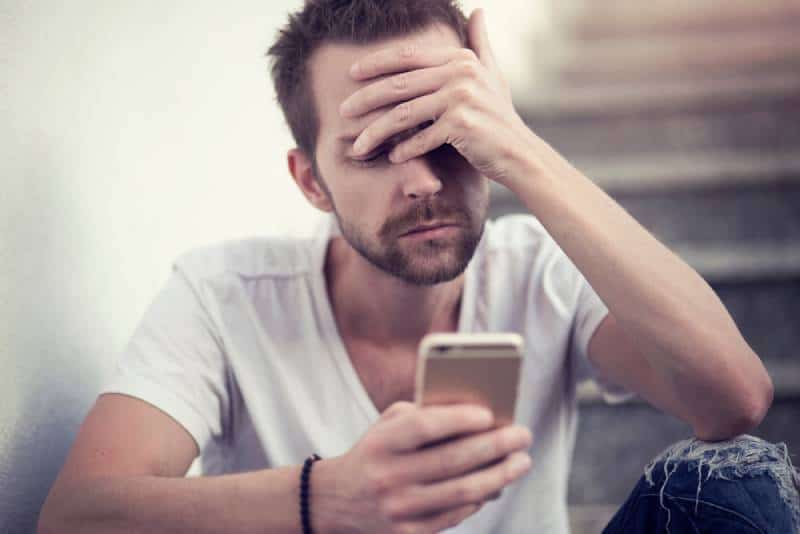 unhappy man looking at his phone