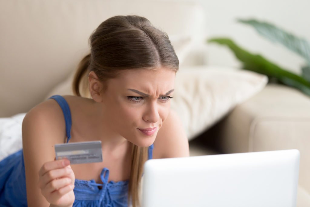 Confused woman having problem with credit card when paying online