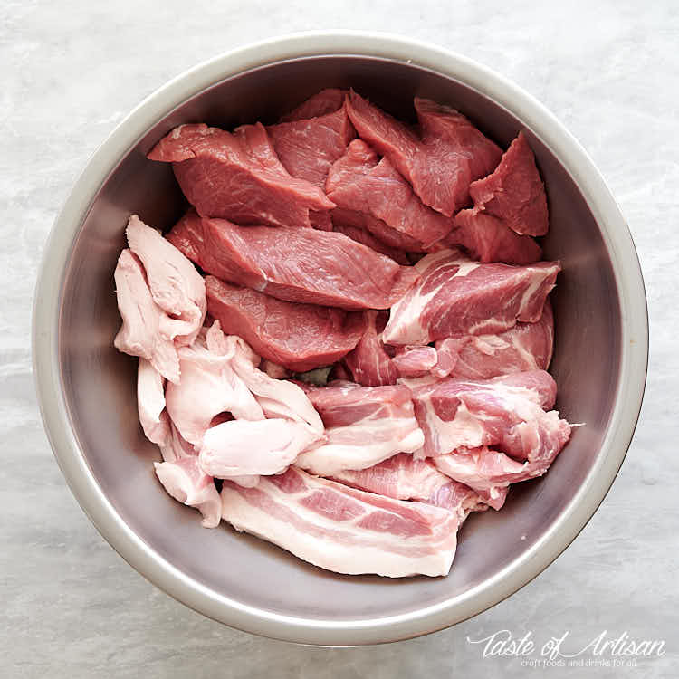 Slice meat with bockwurst sausage seasonings in a stainless steel bowl.