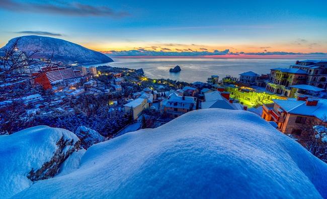 Viewed from a hill, we see a snowy seaside town, lit by colorful sunsets. Why did Jesus come to earth? HE came to give us all hope of eternal life with His Father in heaven.