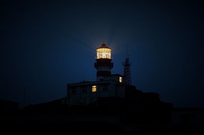 A lighthouse beams its light across the dark sky. Jesus came to earth as our beacon of light!