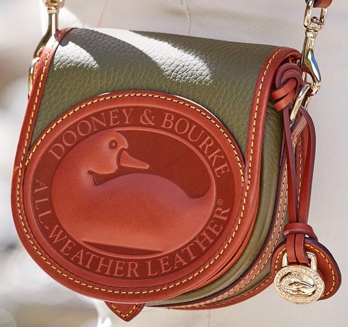 The Dooney & Bourke handbag is finished with a neat coat and polished gold hardware