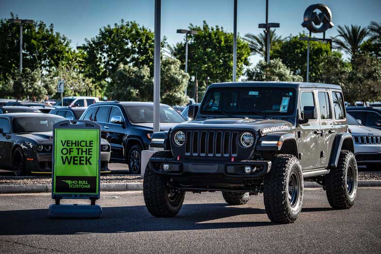 Black Jeep Wrangler parked next to a vehicle for the week