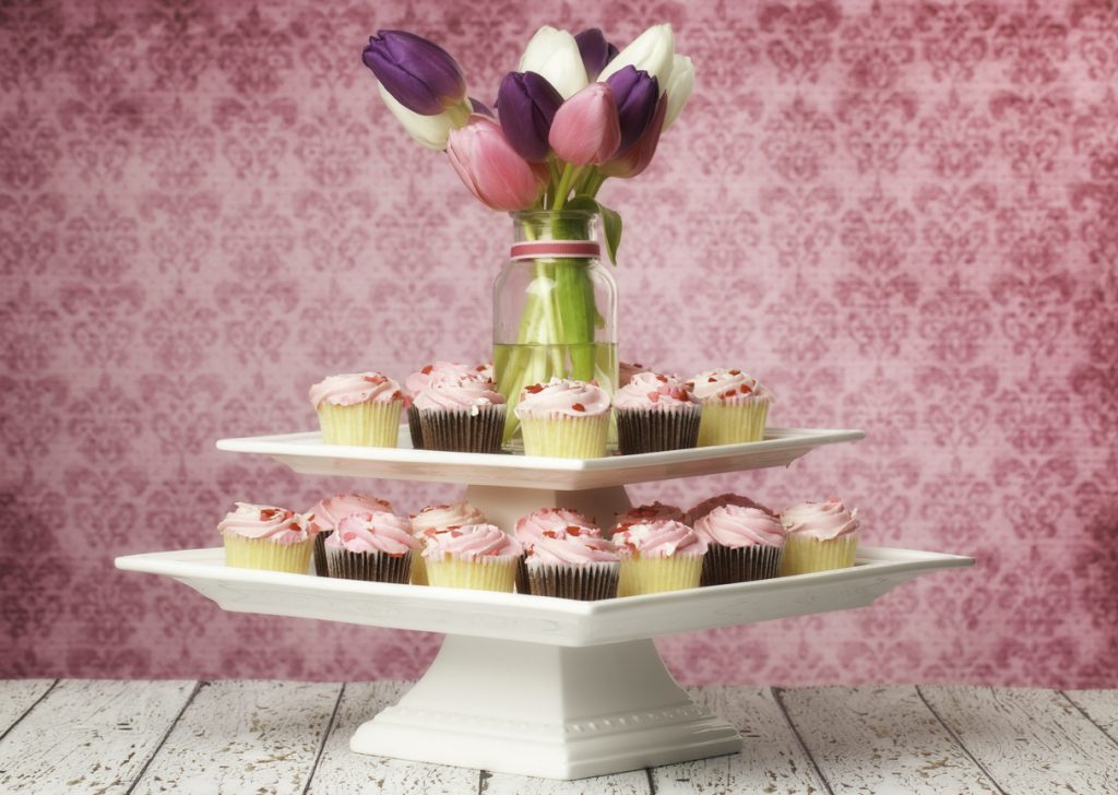 Birthday cupcake centerpiece with pink frosted cupcakes, decorated with hearts and tulips.
