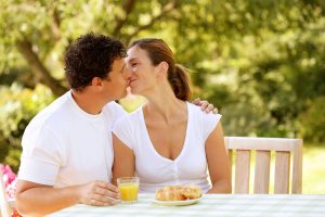 couple kissing at breakfast