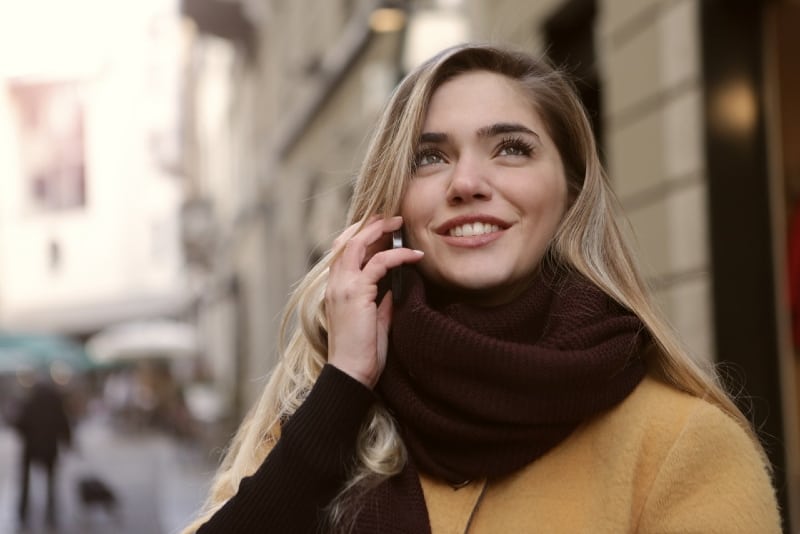 blonde woman with brown scarf talking on the phone