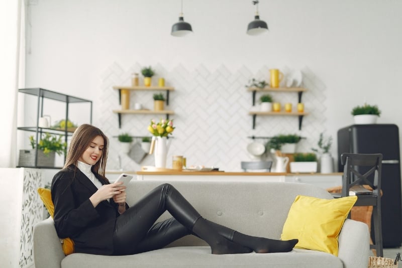 woman using phone while sitting in living room