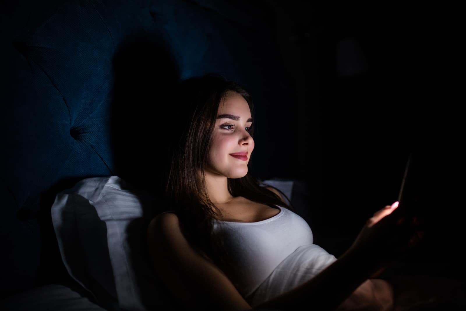 woman lying in the dark texting