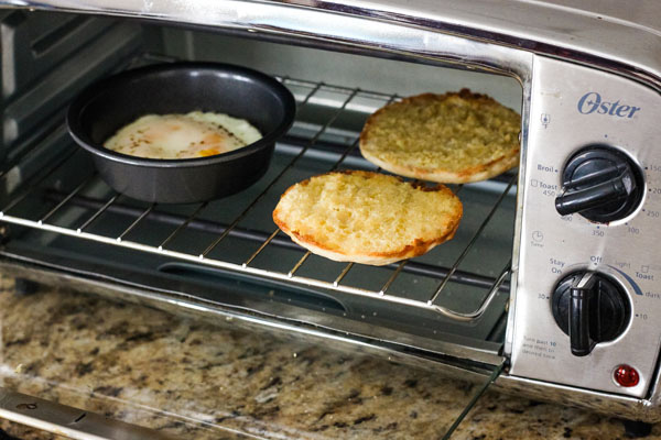 Cooked eggs and half-baked English muffins inside the toaster.