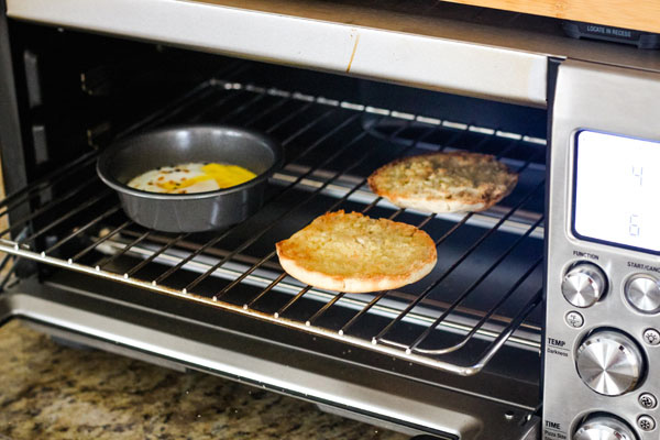 Cooked eggs and half-cut English muffins inside the Breville Pro Smart Oven
