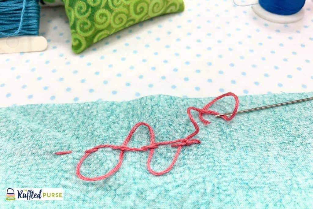 Weave back through the stitches toward the knot