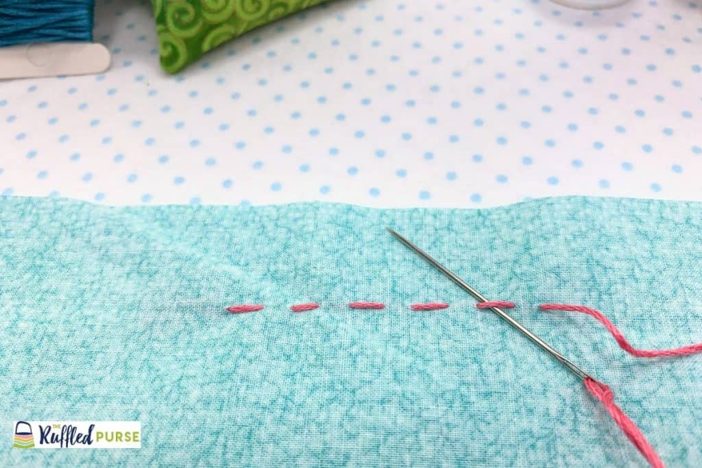 Pass needle under a stitch.