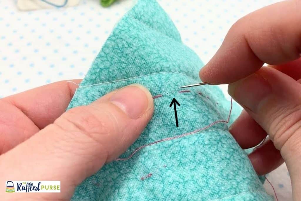 Take a short backstitch where the arrow is pointing.