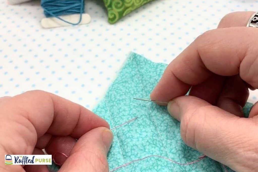 Hold needle and thread. One in each hand.
