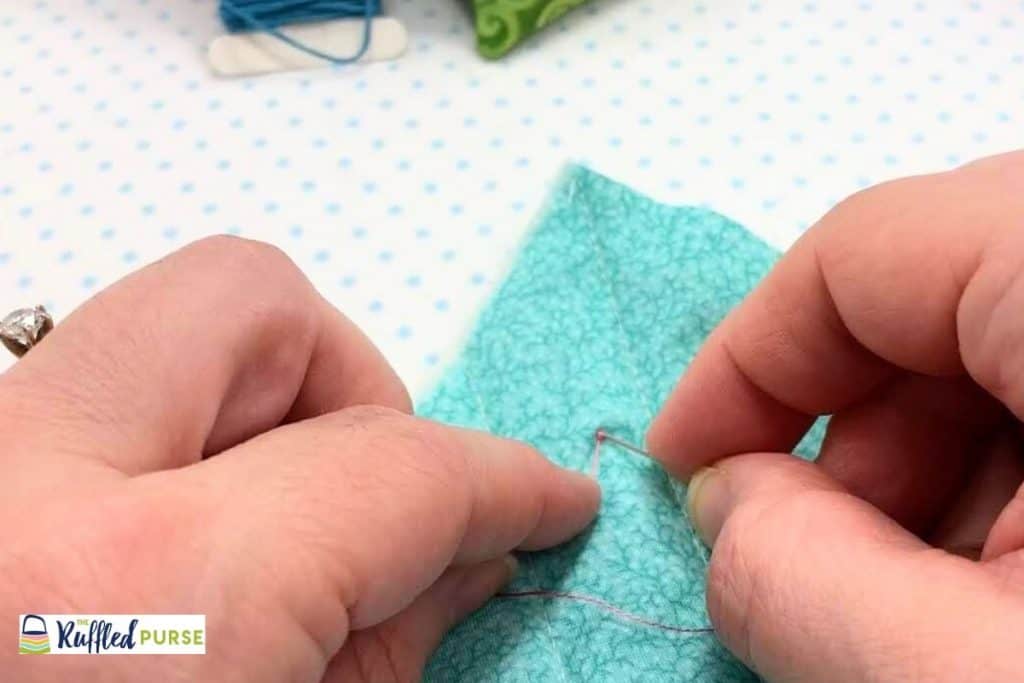 Insert needle close to where the thread is coming out of the fabric.