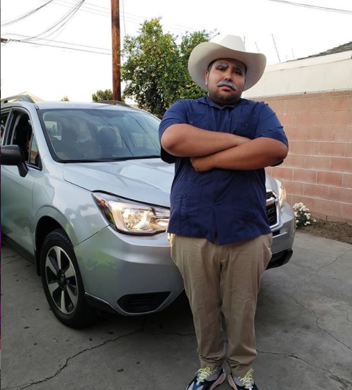 Don Cheto poses for a photo with his car in the background