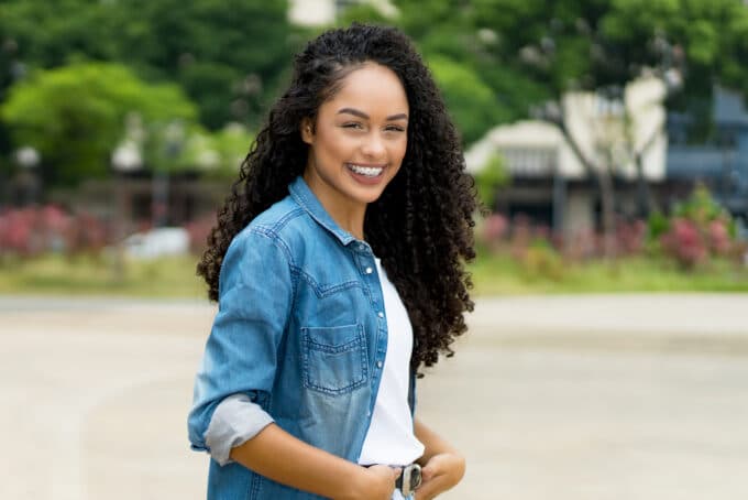 African American women wearing a blue jean outfit and a white t-shirt with type 3c natural hair.