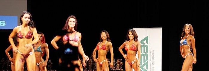 Female bodybuilders on a well lit stage.