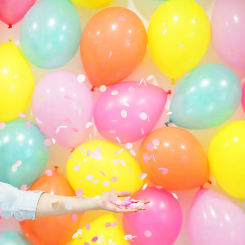 Pastel color ball with a girl throwing pink confetti.