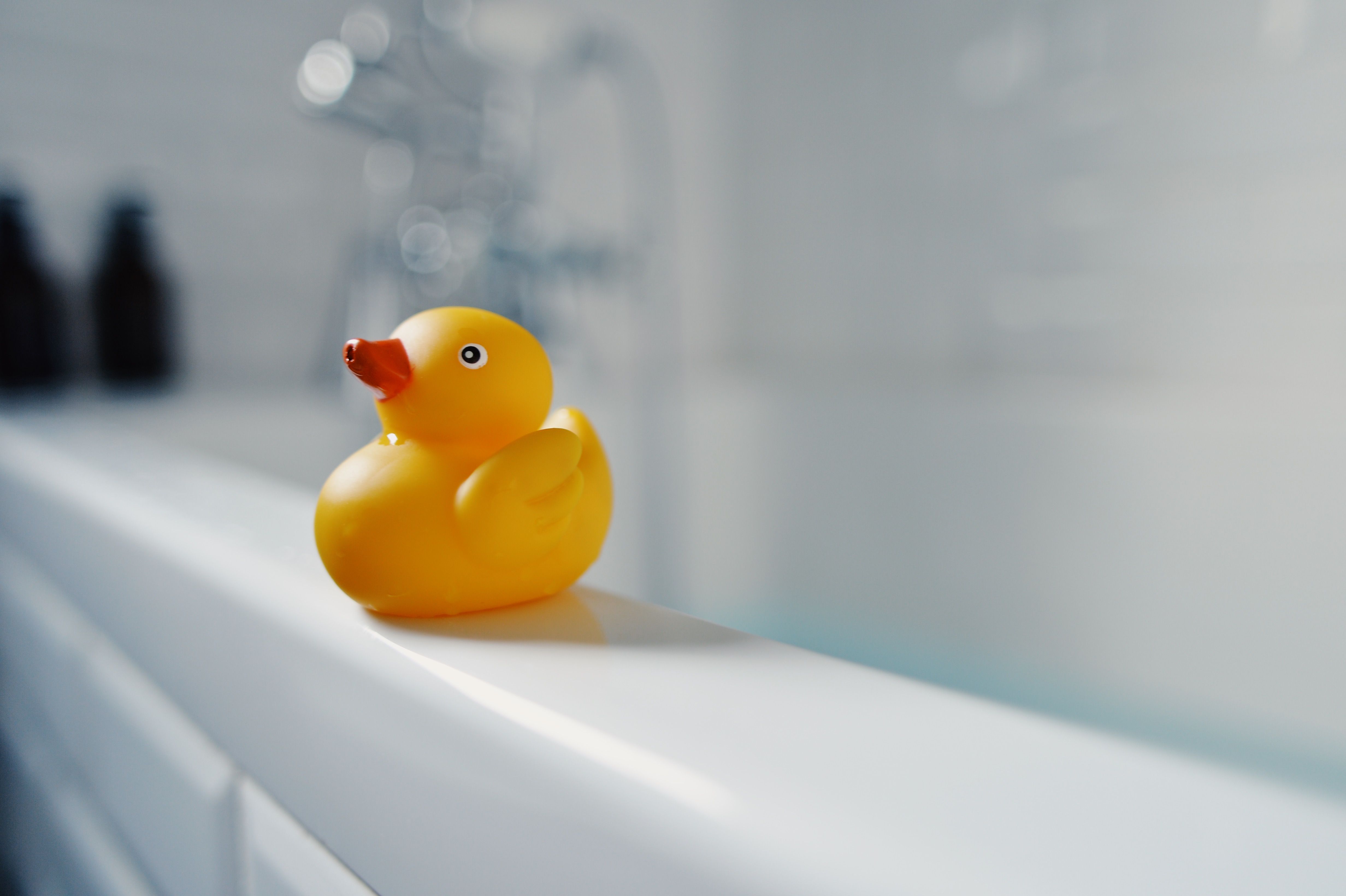 Yellow toy rubber duck by the bathtub