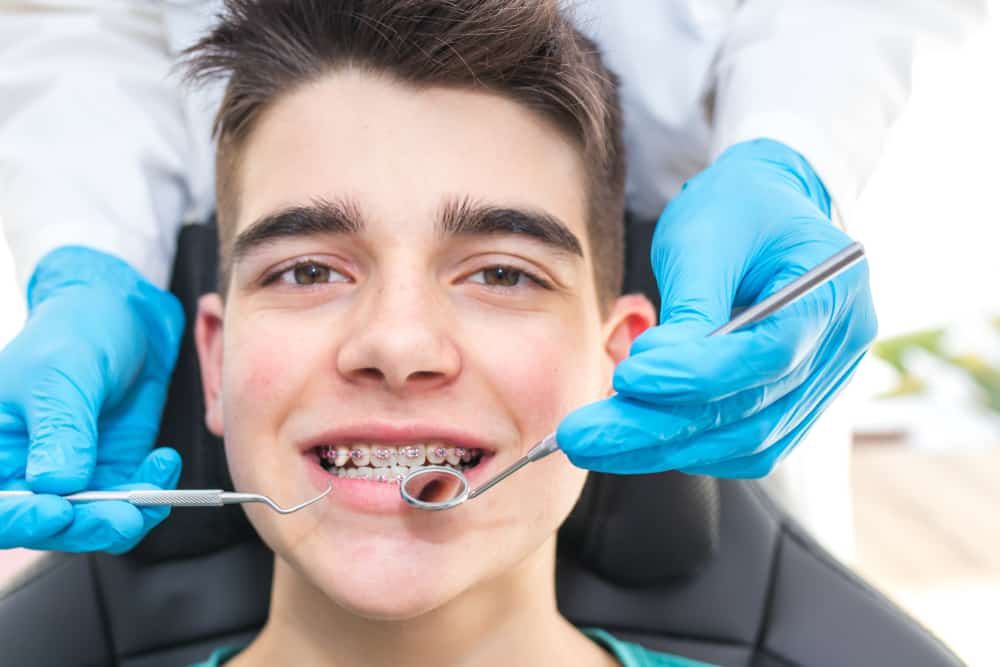 dentist with tools in the young man
