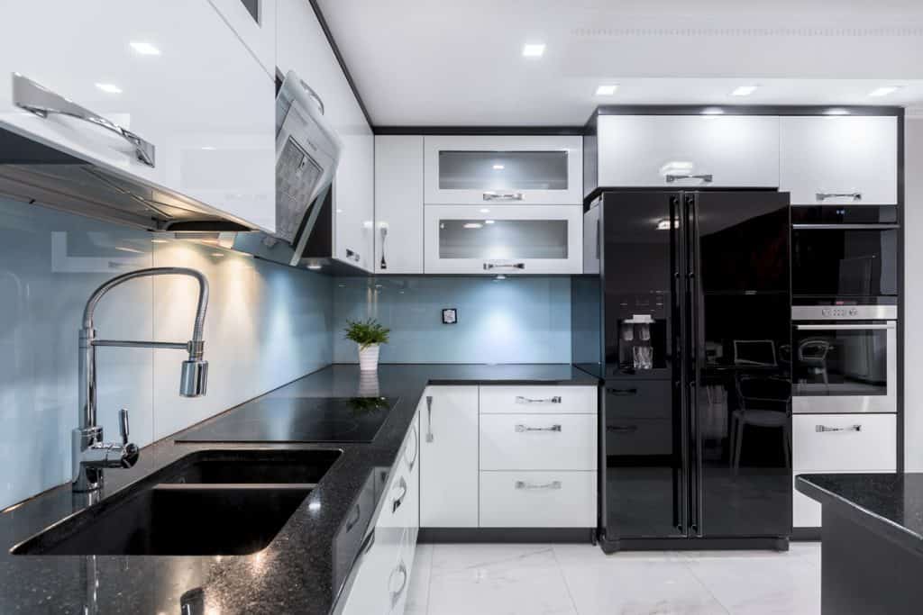 Ultra-modern kitchen with black granite countertops and white cabinets