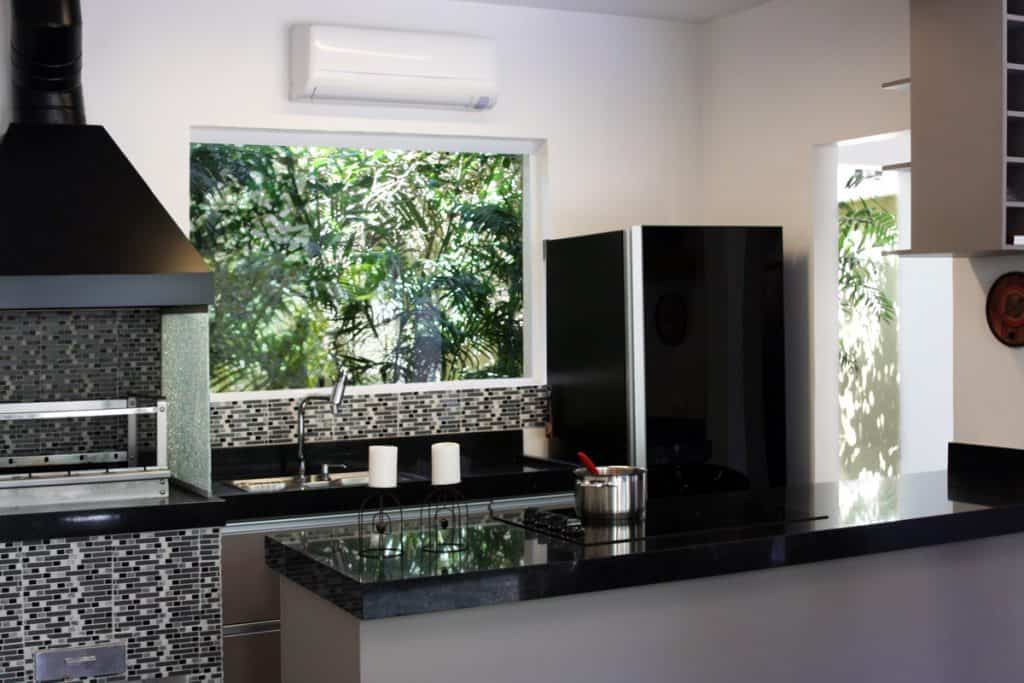 Kitchen with marble countertops, faux stone walls and black cabinets