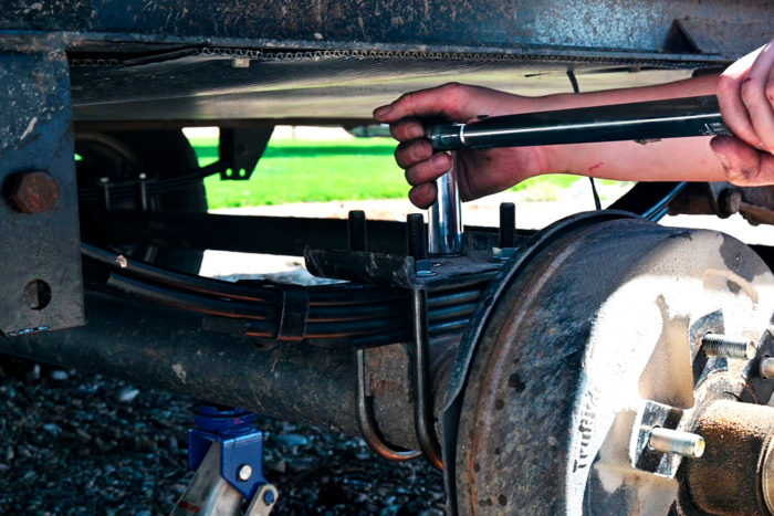 Loosen the U-bolt nuts before removing the shackle bolts that hold up the leaf springs.