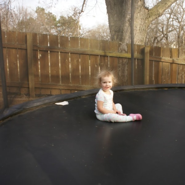 toddler sitting on a trampoline