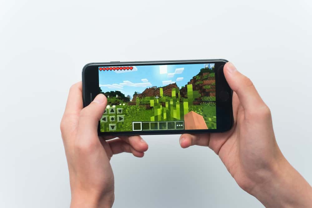 young guy playing minecraft game on Iphone 8 Plus