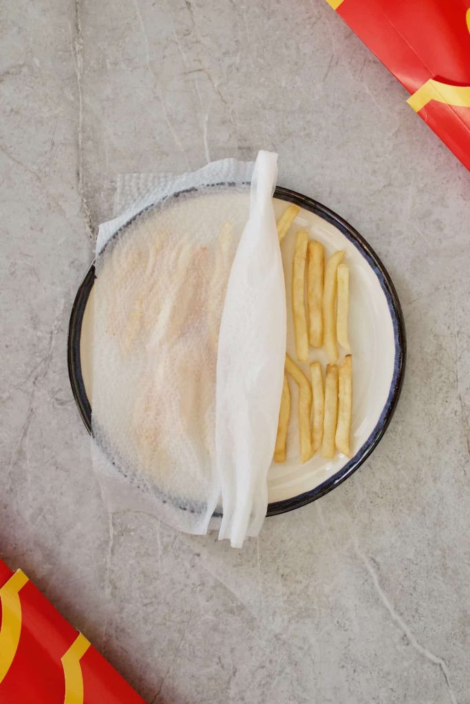 mcdonalds fries on microwave safe plate covered with a damp paper towel