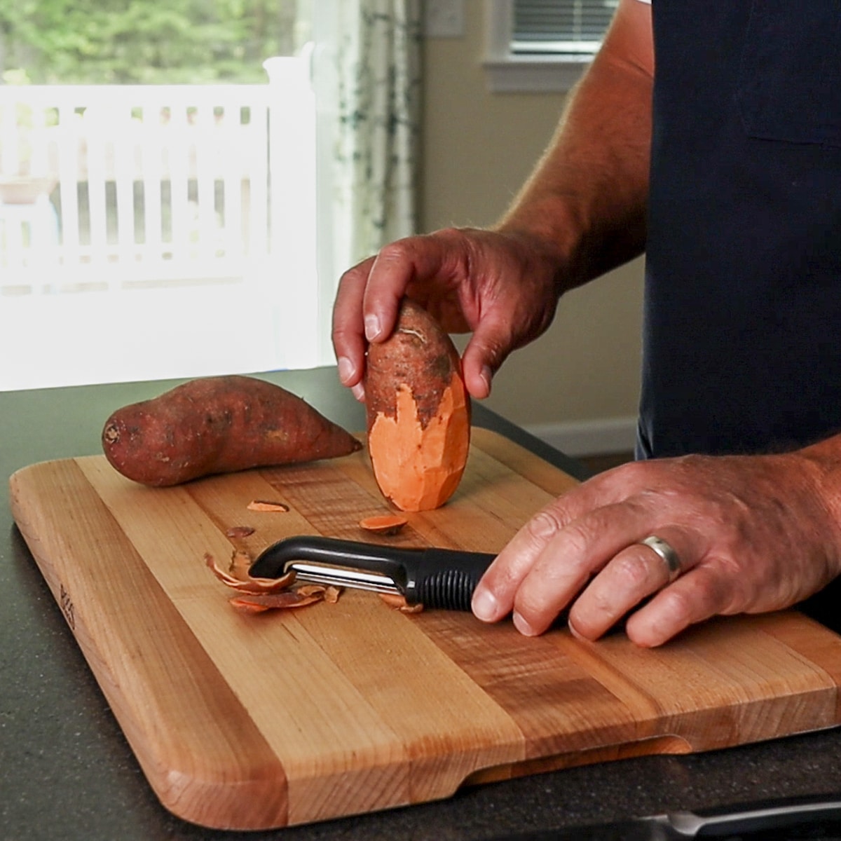 Peel sweet potatoes on a cutting board