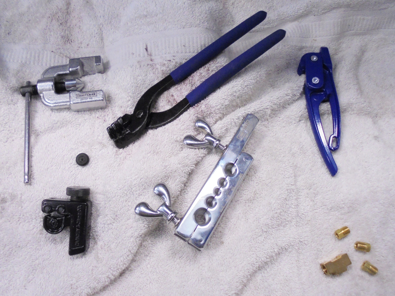 Here is everything you need to make your own brake lines: tube nuts, a double-flaring tool, some tubing benders, and a small pipe cutter. And you will want some towels because you are going to make a mess with your brake fluid, which is very corrosive to paint.