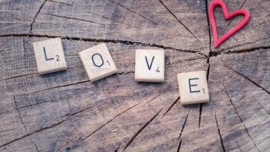 The word love written with scrabble pieces near a heart shape