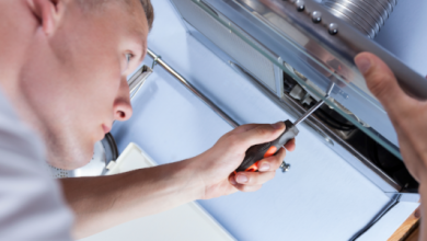 man touching screwdriver to a range hood
